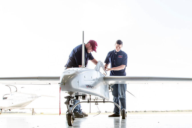 Student and instructor in the Uncrewed Aircraft Systems working on a drone in the hangar.