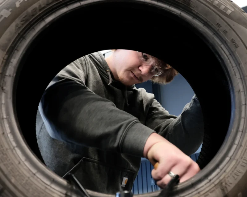 Crosby Hruska, a senior at Thompson High School, works to repair a tire in an automotive class at the Career Impact Academy during the Grand Forks school's inaugural fall 2025 semester.