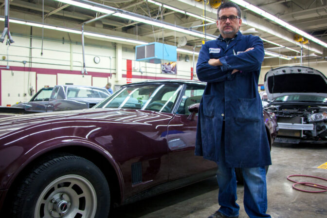 Auto Body Collision Technology instructor in front of cars